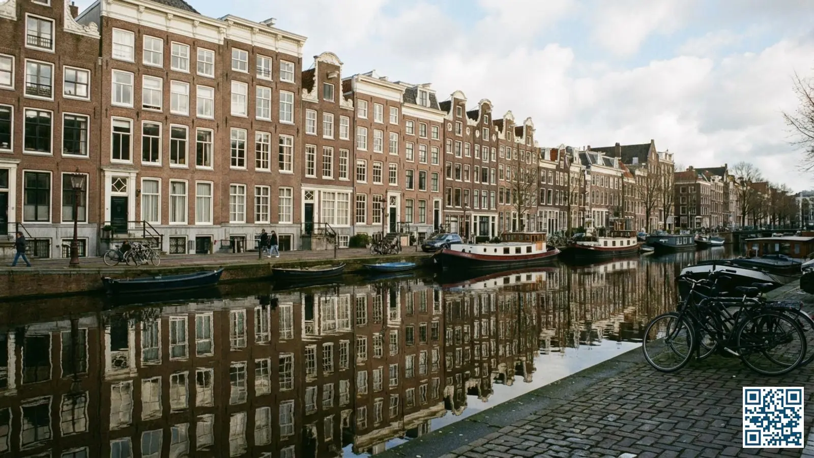 Klassieke Amsterdamse grachtenpanden met karakteristieke grote ramen weerspiegeld in het grachtwater
