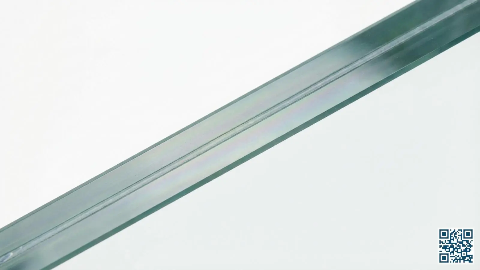 Close-up van gelamineerd glas waarbij de transparante PVB-tussenlaag tussen de glasbladen zichtbaar is