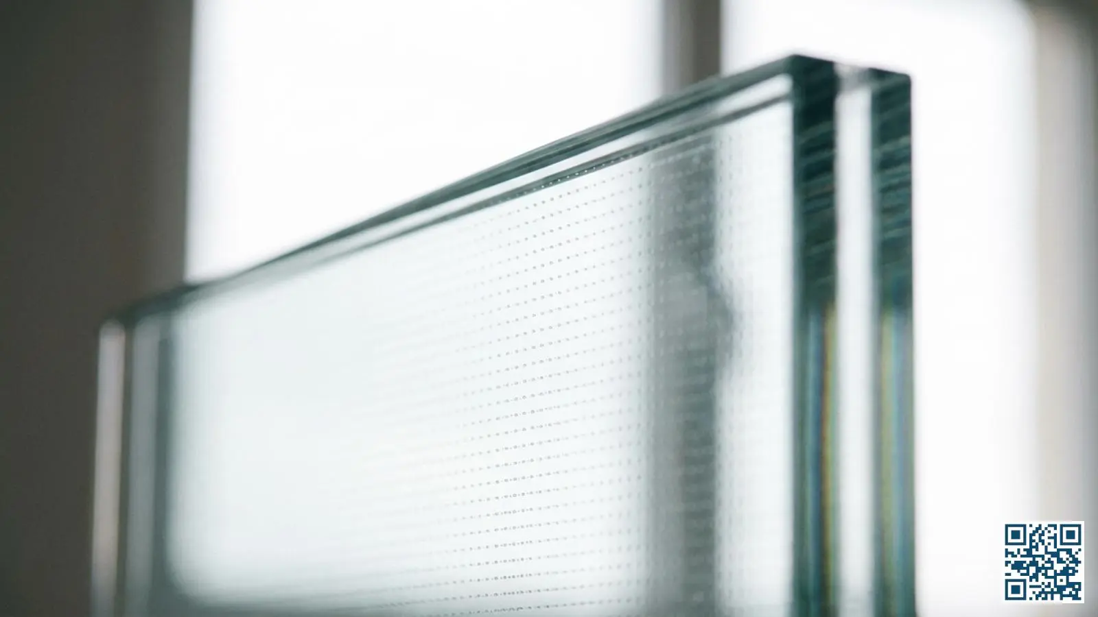 Close-up van vacuümglas waarbij de microscopisch kleine steunpilaren tussen de glasbladen zichtbaar zijn als regelmatig patroon